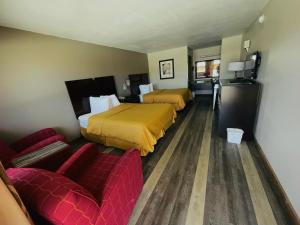 a hotel room with two beds and a couch at Royal Inn & Suites in Mountain Grove