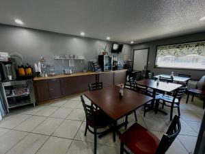 a restaurant with tables and chairs and a kitchen at Royal Inn & Suites in Mountain Grove