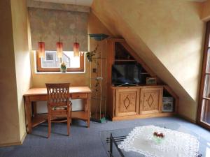Zimmer im Dachgeschoss mit einem Schreibtisch und einem TV in der Unterkunft Appartement im Schlösschen Nr. 2 mit Balkon in Willich