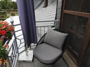una silla con una almohada en el porche en Appartement im Schlösschen Nr. 2 mit Balkon, en Willich