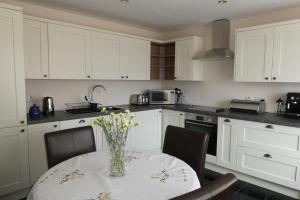 a kitchen with a table with a vase of flowers on it at Caisteal Liath House in Lochinver