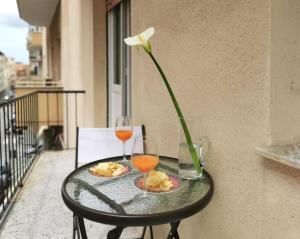 a table with two glasses of wine and a flower at casa mare incantevole in Alghero