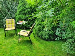 two chairs and a table in the grass at Žltý dom Vrbov in Vrbov