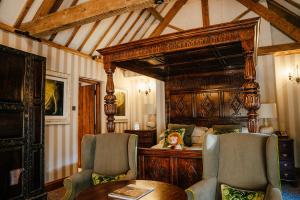 a bedroom with a bed and a table and chairs at The Manor House Hotel and Golf Club in Castle Combe