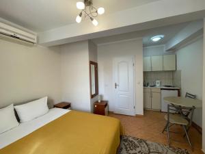 a bedroom with a bed and a table and a kitchen at Villa Semashko in Bar
