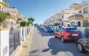 a red car parked on a street next to buildings at Cozy Home In Torrevieja With Wifi in Torrevieja +13 photos