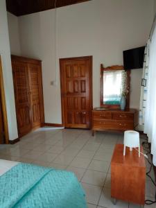 1 dormitorio con 1 cama, vestidor y TV en Zuri Enterprise, en Negril