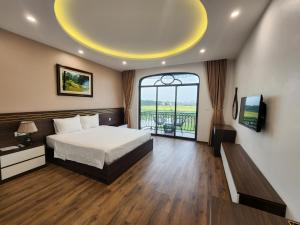 a bedroom with a bed and a large window at Lotus Hotel Ninh Bình in Ninh Binh