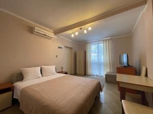 a hotel room with a large bed and a television at Villa Semashko in Bar