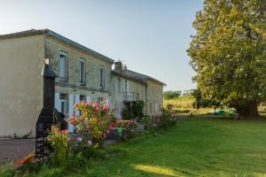 an old house with flowers in front of it at Chambre d'hôte près Bordeaux au château Camponac in Bourg-sur-Gironde