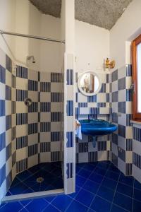 a bathroom with a blue sink and a mirror at Villa Bados 8 - Klodge in Olbia
