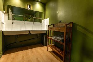 a green bathroom with a sink and a shelf at Chambre d'hôte près Bordeaux au château Camponac in Bourg-sur-Gironde +24 photos