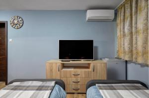 a room with two beds and a television on a cabinet at Top Center, Sea Garden, Brand New Studio - Majestic in Burgas City