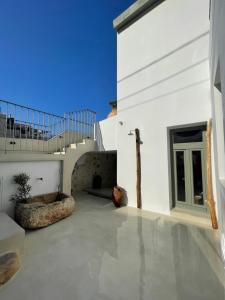 a white house with a concrete floor and a balcony at Lithos Retreat 2(ΛΙTHOS Retreat) in Kolymvari