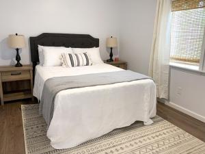 ein Schlafzimmer mit einem weißen Bett und zwei Nachttischen in der Unterkunft Newly Remodeled Stouchsburg Cottage in Myerstown