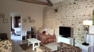 a living room with a couch and a tv at Gîte de l'Octroy Poitou in Oiron