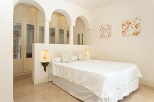 1 dormitorio blanco con 1 cama blanca grande y 2 almohadas en Villa 10.3, en Corralejo