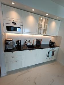 a white kitchen with a sink and a microwave at ORLIK in Gdynia