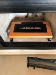 a stove top oven with a wooden tray on top at Cabana Sol - Estalagem Meraki, Cunha SP in Cunha