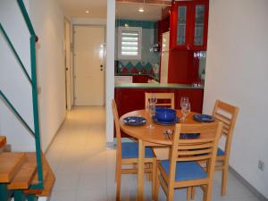 a kitchen with a wooden table with chairs and a dining room at Apartamentos Mar D'Or in L'Estartit