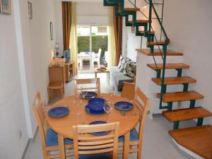 a dining room with a table and chairs and a staircase at Apartamentos Mar D'Or in L'Estartit