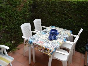 a table with white chairs and a blue bowl on it at Apartamentos Mar D'Or in L'Estartit