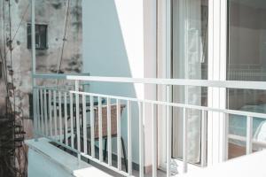 einen Balkon mit einem weißen Geländer und einem Fenster in der Unterkunft Comfortable apartment in the city center in Kateríni