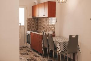 Comfortable apartment in the city center في كاتريني: مطبخ مع طاولة مع كراسي ومغسلة