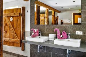 two sinks in a bathroom with two pink bunny towels at Vordersattlegghofhütte in Hüttau