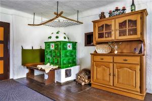 a room with a fireplace and a green stove at Vordersattlegghofhütte in Hüttau