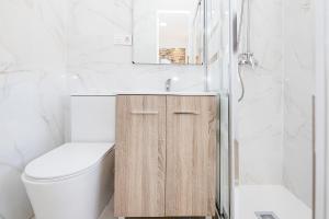 a bathroom with a toilet and a sink and a mirror at Marmoles 21, City Center Apartment in Málaga