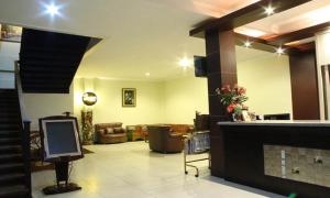 a lobby with a television and a living room at Jazz Hotel Palu in Palu