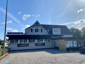 een groot wit huis met een garage bij Blommenslyst Kro in Blommenslyst