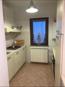 una cucina con finestra con tenda blu di Colline Di Barengo Apartment a Momo