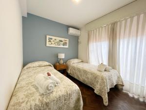 a room with two beds with towels on them at Amplio Piso Vintage, Terraza con Vista a Sierras in Cordoba