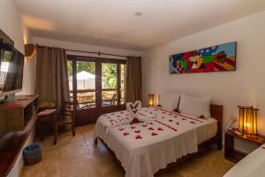 a bedroom with a large bed and a balcony at Pousada Carcará in Jericoacoara