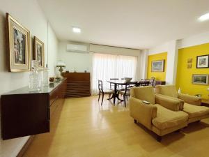 a living room with a couch and a dining room at Amplio Piso Vintage, Terraza con Vista a Sierras in Cordoba