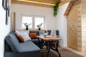 a living room with a blue couch and a table at Podhalańska Ostoja Apartament in Biały Dunajec