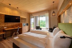 a room with two beds and a desk and a television at Landhotel Zum Goldenen Kreuz in Moosbach