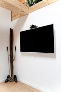 telewizor z płaskim ekranem wiszący na białej ścianie w obiekcie Podhalańska Ostoja Apartament w Białym Dunajcu