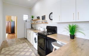 a kitchen with a black stove and white cabinets at The BeeKeeper's Inn in Louis Trichardt