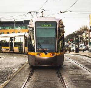 a tram is traveling down the tracks on a street at Yugo Highfield Park - Dublin City in Dublin