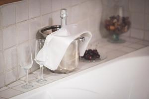 un lavandino con due bicchieri di vino e un rubinetto di Wood Loft Solferino a Bologna