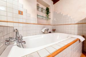 y baño de azulejos blancos con bañera blanca. en Wood Loft Solferino, en Bolonia