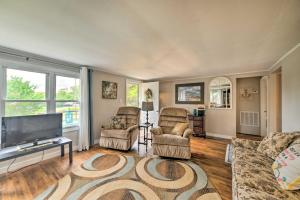 a living room with two chairs and a flat screen tv at Cheerful Grand Rivers Cottage, half Mi to Lake in Grand Rivers