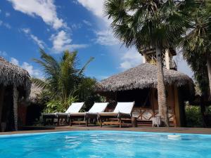 a group of lounge chairs and a swimming pool at Terra Patris in Barra Grande