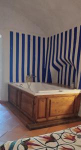 a wooden bench in a room with a striped wall at Casas Cueva La Tala in Guadix