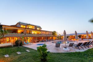 a large building with a pool and chairs and umbrellas at Casa Di Datca in Datca