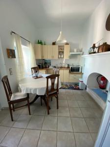a kitchen with a table and chairs and a fireplace at Kleopatra Sweet Home in Symi