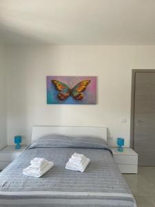 - une chambre avec un lit orné d'une peinture murale aux papillons dans l'établissement B&B Il Dolce Nido, à Tortora